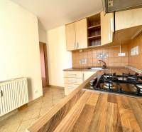 Zrekonštruovaný 3i byt na začiatku Petržalky, električka, les, výhľady - Kuchyňa s podlahou s dreveným dekorom a plynovým sporákom v 3-izbovom byte.