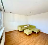 Zrekonštruovaný 3i byt na začiatku Petržalky, električka, les, výhľady - Obývacia izba s rohovou sedačkou a podlahou s dreveným dekorom v 3-izbovom byte.