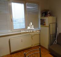 1 - izbový byt Košice, Popradská - Izba s oknom, prúžkovanými žalúziami, podlahou s dreveným dekorom a chladničkou v 1-izbovom byte.