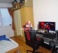 1 - izbový byt Košice, Popradská - Pracovný kútik s počítačom, lôžkom a podlahou s dreveným dekorom v 1-izbovom byte.