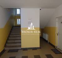 1 - izbový byt Košice, Popradská - Chodba v bytovom dome Košice - Západ, so schodiskom a radiátorom na stenách.