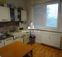 1 - izbový byt Košice, Popradská - Kuchyňa v 1-izbovom byte s podlahou s dreveným dekorom a jedálenským stolom.