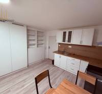 EXKLUZÍVNE: Štýlové bývanie v tichej lokalite Kanaša – po kompletnej r - Kuchyňa v rodinnom dome s bielou linkou, vstavanými poličkami a podlahou s dreveným dekorom.