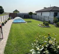 Tehlová novostavba s bazénom a terasou – Geča pri Košiciach - Záhrada rodinného domu v Geči s bazénom a rovinatým, úhľadným trávnikom.