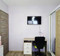 Tehlová novostavba s bazénom a terasou – Geča pri Košiciach - Detská izba s televízorom, stolíkom a podlahou s dreveným dekorom v Rodinnom dome.