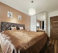 Tehlová novostavba s bazénom a terasou – Geča pri Košiciach - Spálňa s posteľou a zrkadlovou skriňou, podlaha s dreveným dekorom, Rodinný dom.