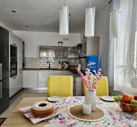 Tehlová novostavba s bazénom a terasou – Geča pri Košiciach - Kuchyňa v rodinnom dome s jedálenským stolom, sviečkami a ovocím.