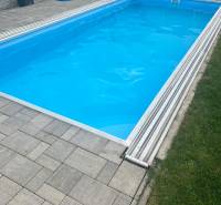 Tehlová novostavba s bazénom a terasou – Geča pri Košiciach - Rodinný dom v Geči obsahuje bazén s krytom, obklopený dlažbou a zeleňou.