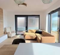 LUXUSNÝ 3i byt,PARKING,CHLADENIE,TERASA,Grand Koliba, Frankovská ulica - Obývačka v 3-izbovom byte s gaučom, kreslom, vstavanou skriňou a priamym výhľadom na terasu.