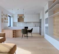 LUXUSNÝ 3i byt,PARKING,CHLADENIE,TERASA,Grand Koliba, Frankovská ulica - Svetlý obývací priestor s kuchyňou a balkónom, 3-izbový byt, s drevenými prvkami.