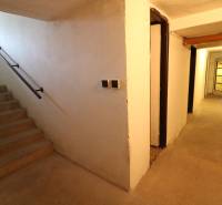 Na predaj 8 izbový rod. dom v lukratívnej časti - Rača - Schodisko s chodbou v interiéri, priestor pôsobí jednoducho, na stene grafika leva.
