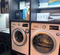 Priestranný 5-izbový rodinný dom s pohodlným dojazdom do Bratislavy  - Práčovňa v rodinnom dome s práčkou, sušičkou, regálom a čistiacimi prostriedkami.