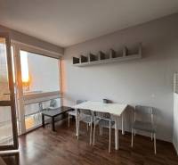 Prenájom 2-izb byt v uzavretom areáli Bratislava II - Obývacia izba v 2-izbovom byte s podlahou s dreveným dekorom a jedálenským setom.