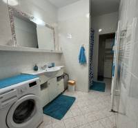 Prenájom 2-izb byt v uzavretom areáli Bratislava II - Kúpeľňa v 2-izbovom byte s práčkou, bielymi kachličkami a modrými doplnkami.