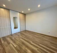 PRENÁJOM - 1-izbový priestranný byt byt - Klokočina, Škultétyho - Izba v 1-izbovom byte s podlahou s dreveným dekorom a vstavanou skriňou.