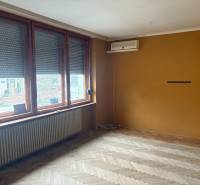 PREDAJ - Rodinný dom s investičným potenciálom - Nové Zámky - Interiér rodinného domu s podlahou s dreveným dekorom, veľkými oknami a klimatizáciou.