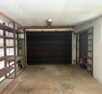 PREDAJ - Rodinný dom s investičným potenciálom - Nové Zámky - Garáž v rodinnom dome s policami a rolovacími dverami.