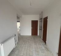 PREDAJ - Rodinný dom s investičným potenciálom - Nové Zámky - Interiér rodinného domu s bielymi stenami, radiátorom a podlahou so svetlým dekorom.