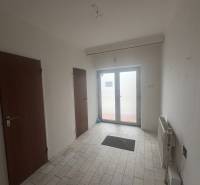 PREDAJ - Rodinný dom s investičným potenciálom - Nové Zámky - Interiér rodinného domu s bielymi stenami, keramickou podlahou a drevenými dverami.