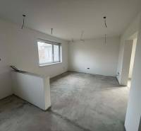 PREDAJ - 3-izbový rodinný dom po kompletnej interiérovej rekonštrukcii - Priestranná miestnosť v rodinnom dome s veľkým oknom a betónovou podlahou.
