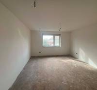 PREDAJ - 3-izbový rodinný dom po kompletnej interiérovej rekonštrukcii - Prázdna izba v rodinnom dome s podlahou s dreveným dekorom a oknom bez závesov.