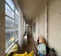 PREDAJ - Rodinný dom na rekonštrukciu s veľkým pozemkom – Kuraľany - Zasklená chodba v rodinnom dome s výhľadom a odloženými predmetmi na podlahe.