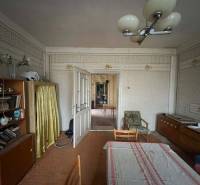 PREDAJ - Rodinný dom na rekonštrukciu s veľkým pozemkom – Kuraľany - Obývačka v rodinnom dome s retro nábytkom a tapetami.