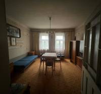 PREDAJ - Rodinný dom na rekonštrukciu s veľkým pozemkom – Kuraľany - Obývacia izba v rodinnom dome s koberecom a historickým nábytkom.