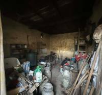 PREDAJ - Rodinný dom na rekonštrukciu s veľkým pozemkom – Kuraľany - Úložný priestor s rôznym náradím a kovovými nádobami v rodinnom dome.