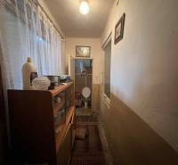 PREDAJ - Rodinný dom v obci Kamenica nad Hronom – len 5 km od Štúrova - Úzky koridor v rodinnom dome s klasickým vybavením, záclony a nábytok na uloženie.