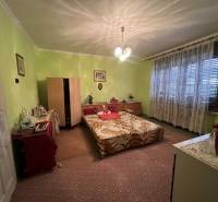 PREDAJ - Rodinný dom v obci Kamenica nad Hronom – len 5 km od Štúrova - Spálňa v rodinnom dome s kobercovou podlahou, posteľou, komodami a svetlozelenými stenami.