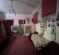 PREDAJ - Rodinný dom v obci Kamenica nad Hronom – len 5 km od Štúrova - Obývacia izba v rodinnom dome s červenými skrinkami, televízorom a dekoratívnym stolom.