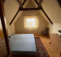 PREDAJ - Zrekonštruovaná rekreačná chata - Chľaba - Podkrovná izba v chate s posteľou, komodou, stoličkou a veľkým kobercom.