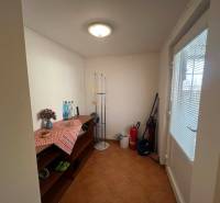 PREDAJ - Zrekonštruovaná rekreačná chata - Chľaba - Interiér chaty s komodou, čistiacimi potrebami a kvetinou na stole.