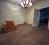 PREDAJ - Rodinný dom s veľkým pozemkom v obci Koplotovce  - Izba v rodinnom dome s lustrami a podlahou s dreveným dekorom, vedľa sú matrace.