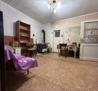 PREDAJ - Rodinný dom s veľkým pozemkom v obci Koplotovce  - Interiér rodinného domu s podlahou, stolom, stoličkami a poličkou.