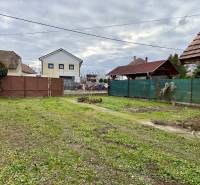 Na predaj pozemok 1065 m2, obec Dobrohošť v blízkosti Bratislavy - Pozemok na bývanie v Dobrohošti na Dobrohošť ulici s trávnatou plochou a bránou.