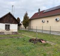 Na predaj pozemok 1065 m2, obec Dobrohošť v blízkosti Bratislavy - Pozemok na bývanie v Dobrohošti. Stará stavba vedľa modernejšieho domu so solárnymi panelmi.