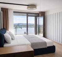 Prenájom 2-izbový byt s loggiou,55m2, EUROVEA TOWER - Spálňa v 2-izbovom byte s výhľadom na rieku, podlaha s dreveným dekorom.