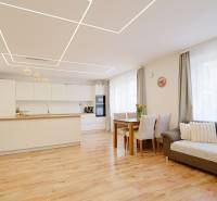 TOP - Rodinný dom s veľkým pozemkom - Dolný Hričov - Interiér rodinného domu s kuchyňou a obývačkou, podlahou s dreveným dekorom a svetlým nábytkom.