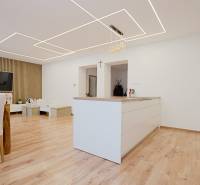 TOP - Rodinný dom s veľkým pozemkom - Dolný Hričov - Kuchyňa a obývačka s podlahou s dreveným dekorom v rodinnom dome.