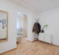 TOP - Rodinný dom s veľkým pozemkom - Dolný Hričov - Interiér rodinného domu s podlahou s dreveným dekorom, komodou a stojanom na kabáty.