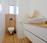 TOP - Rodinný dom s veľkým pozemkom - Dolný Hričov - Kúpeľňa s umývadlom na komode a podlahou s dreveným dekorom.