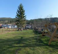 TOP - Rodinný dom s veľkým pozemkom - Dolný Hričov - Záhrada rodinného domu na ulici Mládeže v Dolnom Hričove s hojdačkou a stromami.