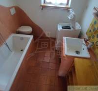 Zrekonštruovaný dom pri potoku v podhorí Veľkej Fatry - Kúpeľňa v rodinnom dome s vaňou, práčkou a farebnými obkladačkami.