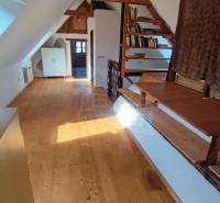 Zrekonštruovaný dom pri potoku v podhorí Veľkej Fatry - Podkrovný priestor s podlahou s dreveným dekorom v rodinnom dome s knižnicou.
