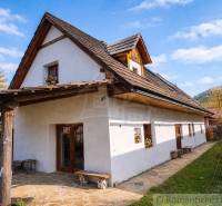 Zrekonštruovaný dom pri potoku v podhorí Veľkej Fatry - Rodinný dom v Blatnici s drevenou strechou a kamenným chodníkom na dvore.