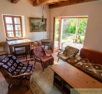 Zrekonštruovaný dom pri potoku v podhorí Veľkej Fatry - Obývacia izba rodinného domu so starožitnými kreslami a dreveným stolom.