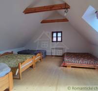 Zrekonštruovaný dom pri potoku v podhorí Veľkej Fatry - Podkrovná izba v rodinnom dome s dreveným dekorom podlahy, pohodlnými posteľami a oknom.