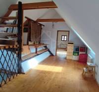 Zrekonštruovaný dom pri potoku v podhorí Veľkej Fatry - Podkrovný priestor s drevenými prvkami a podlahou s dreveným dekorom v rodinnom dome.